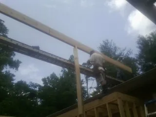 Carpenter setting a ridge beam over a new addition frame — Ice Dam Removal by Roofing Brothers in North Zulch