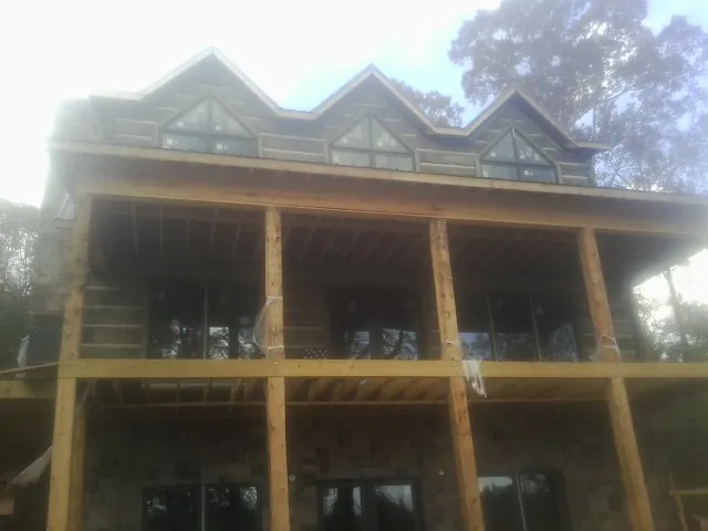 Dormers and porch framing on a large log home under construction — Roof Coating work by our crew in North Zulch